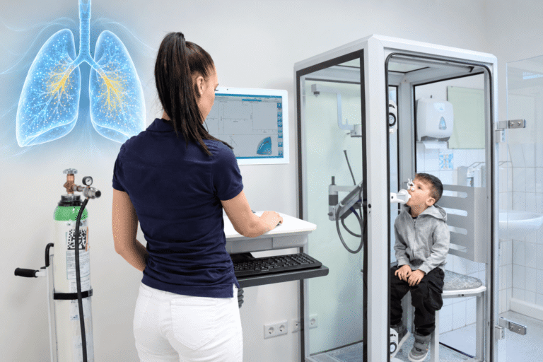 Niño realizando una prueba de lavado de múltiples respiraciones en una cabina de pletismografía pulmonar
